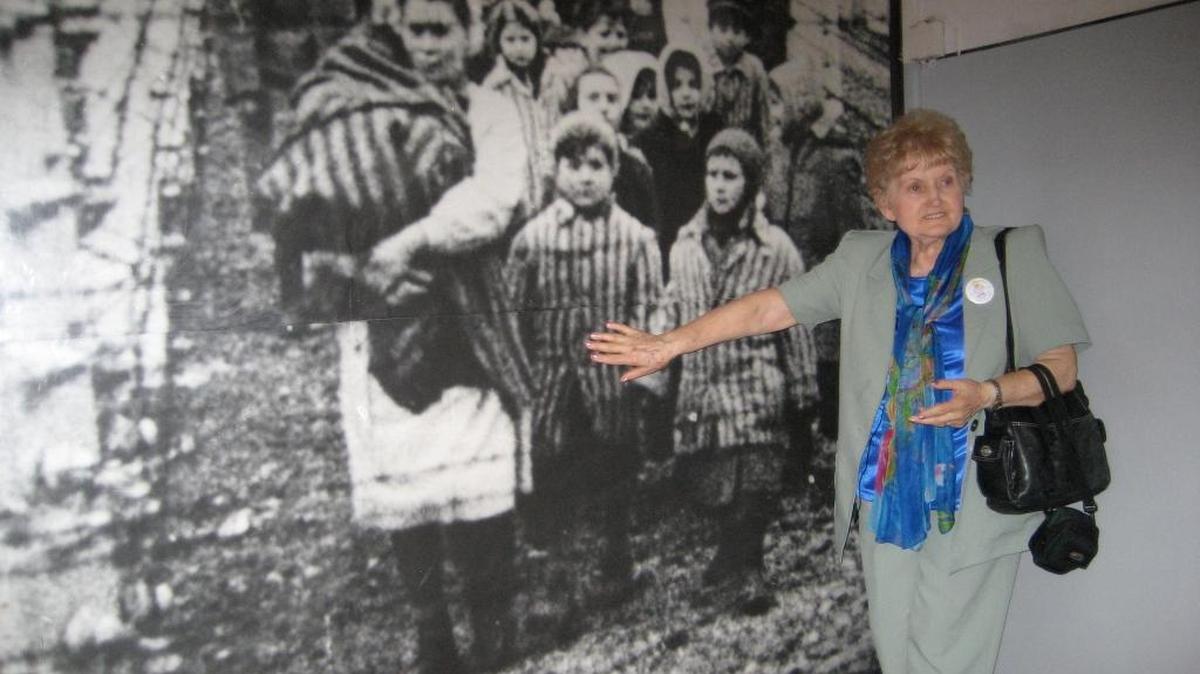 Kor points to herself in a photo displayed at Auschwitz.