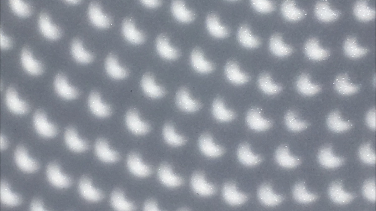 Lola Bellaflores Rovira and her family captured the moon’s crescent shadow as it crossed the sun through the holes of a potato colander at 3:12 p.m. Monday