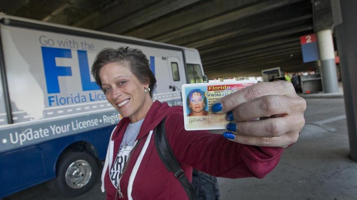 Julie Witter of St. George, VA, gets a temporary Florida ID card from the Florida Licensing on Wheels van at Fort Lauderdale-Hollywood International Airport on Sunday. Witter left some of her belongings behind in the melee caused by the shooting at the airport on Friday.
