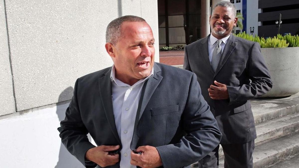 Luis Santiago, former commissioner for the City of Opa-Locka, exits the Federal Courthouse in Miami after surrendering to bribery charges. He pleaded not guilty and was released after posting $50,000 surety bond on Friday, December 30, 2016, while his defense attorney Roderick Vereen looks on.
