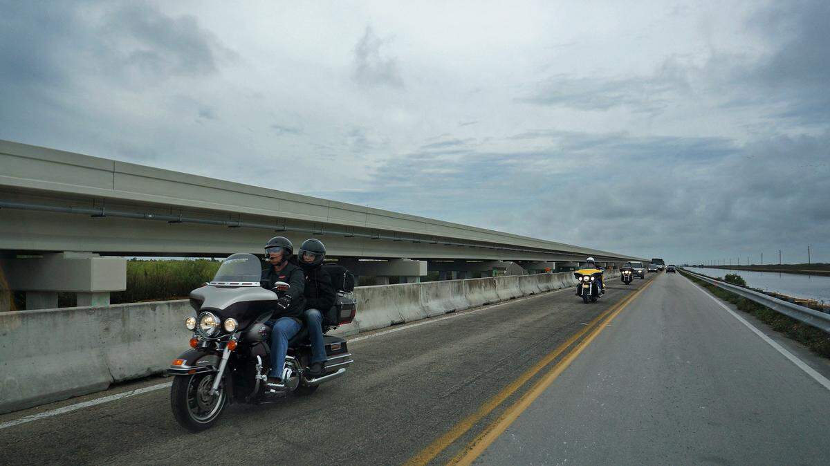 ON THE TAMIAMI TRAIL: Bikers ride along the part of the route that will be removed to allow water to flow under the newly built bridge beside it.                     