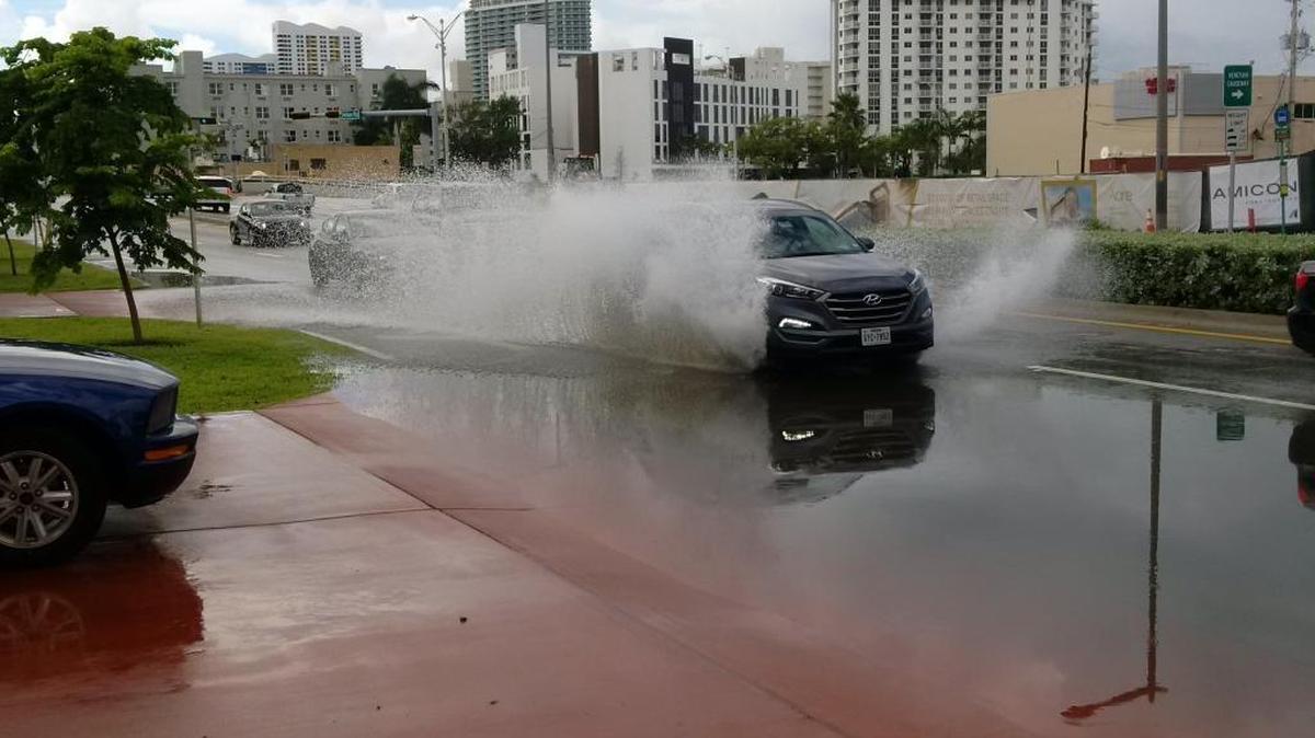 An SUV splashes down Miami Beach’s Alton Road Sunday morning