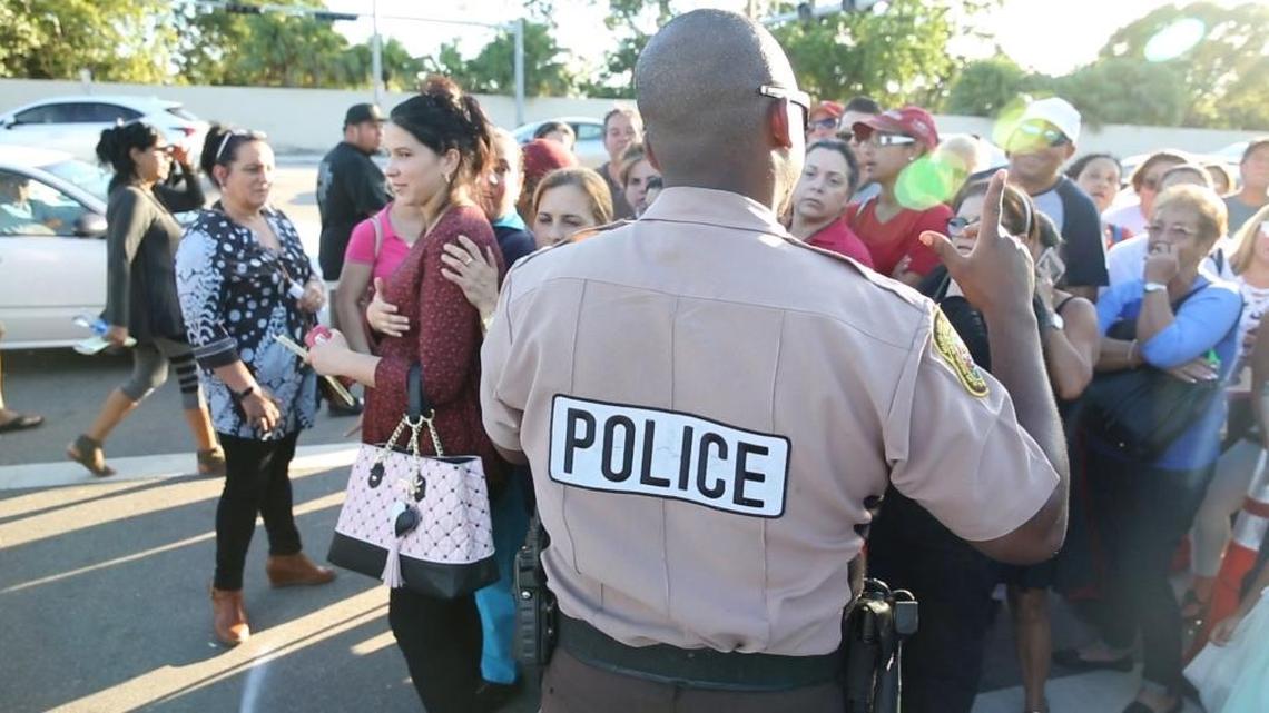 A Miami-Dade police officer encourages people to turn around and go home on Wednesday afternoon after emergency food stamp aid was stopped early at Hard Rock Stadium after reaching capacity. People who expected to be admitted in until 6 p.m. were told around 2:30 p.m. to return on Thursday.
