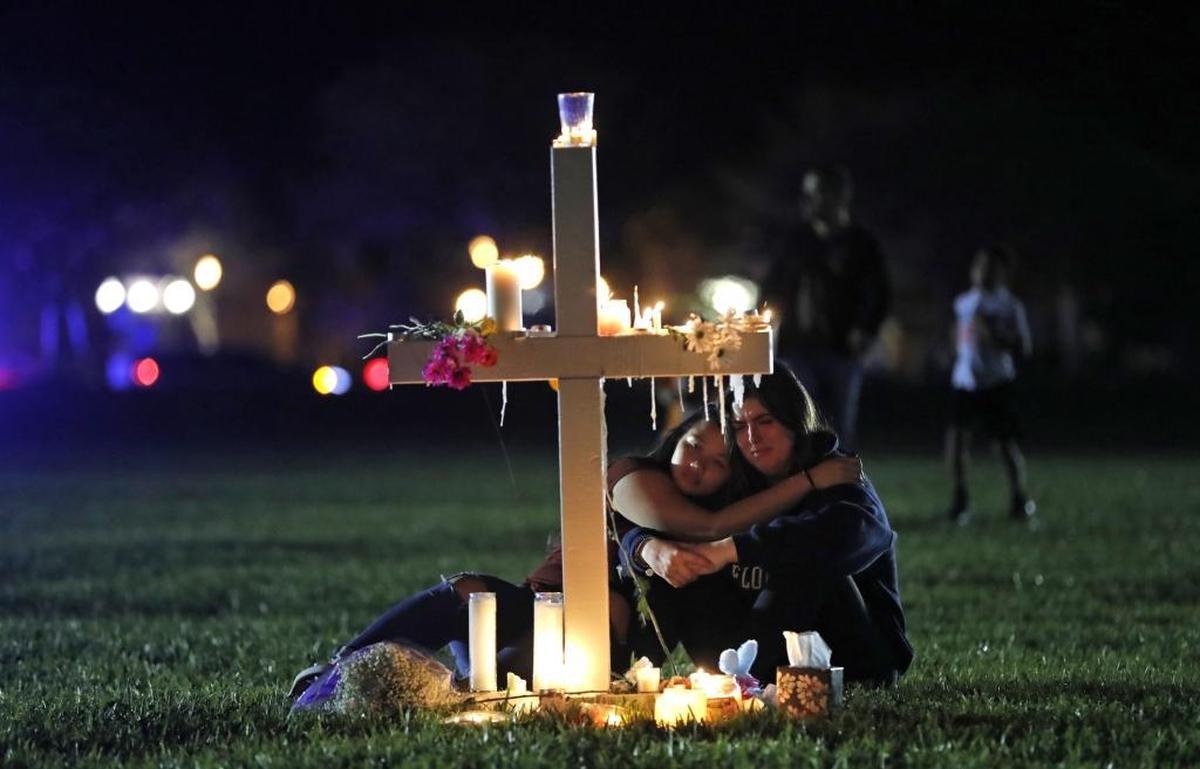 Mourners gathered at one of 17 crosses erected outside Marjory Stoneman Douglas High School for the 17 students and faculty gunned down on Feb. 14.