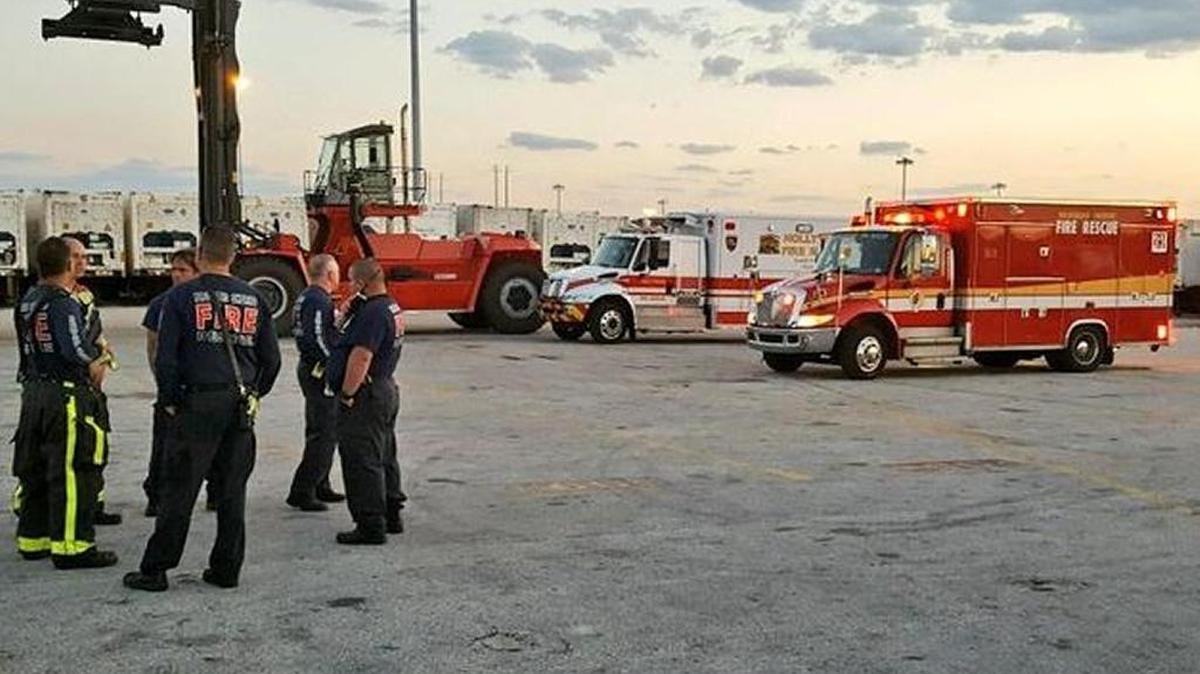 Broward Sheriff Office Fire Rescuers wait outside the scene of a chemical spill at Port Everglades.