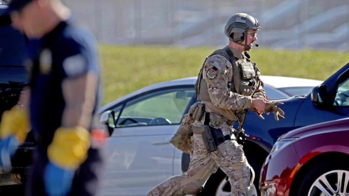 A law enforcement officer rushes toward Marjory Stoneman Douglas High School in Parkland after former student Nikolas Cruz attacked students and staff with a rifle.
