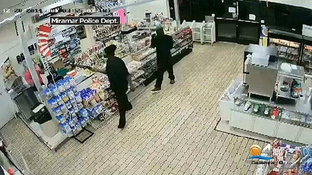 
Video surveillance footage shows the two robbers enter the convenience store.
