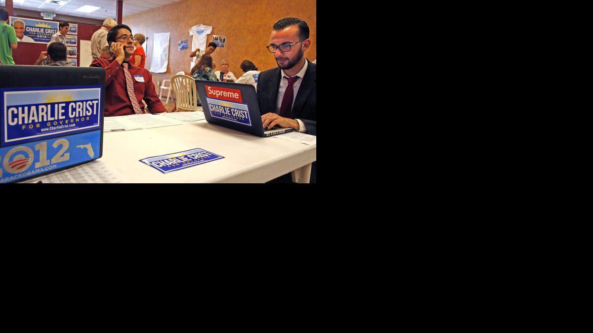 
Voter outreach: Alan Abdin, on the phone, and Saif Mamideh, right, work for Charlie Crist in Davie. Broward County largely holds the key to Democrats’ dreams of a return to power in the 2014 governor’s race. 



