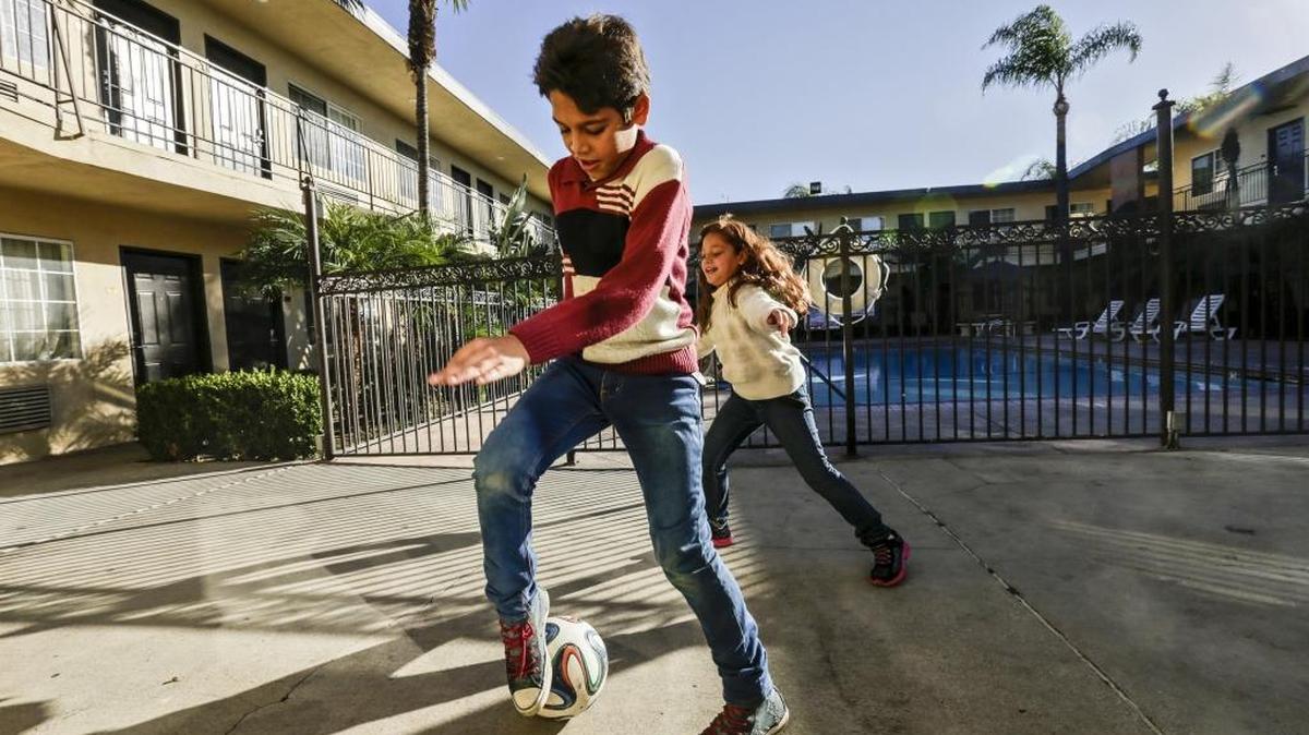 Omran Wawieh, 11, left, and Maram, 8, play in the courtyard of a Pomona, California, motel in where they are staying after arriving from Syria, on Tuesday, Nov. 17, 2015.