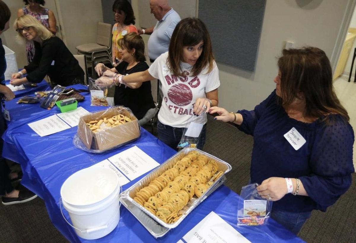 Marjory Stoneman Douglas parent, Barbara Feller, of Coral Springs, and her cousin, Jacquie Brauser of Fort Lauderdale joined other members of South Florida’s Jewish community at the Jewish Federation of Broward in Cooper City, Tuesday, Feb. 27, 2018 to fill more than 5,000 bags for Purim for a Parkland Mitzvah project.