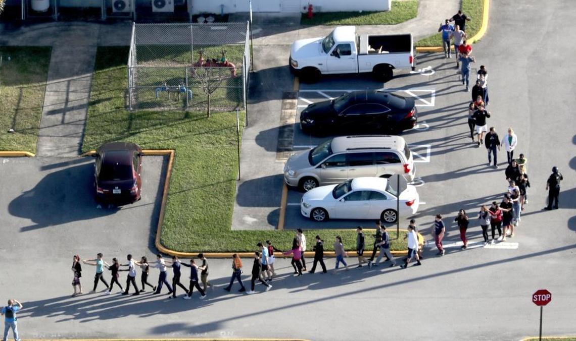 Students are evacuated by police out of Marjory Stoneman Douglas High School in Parkland after a shooter opened fire on the campus.