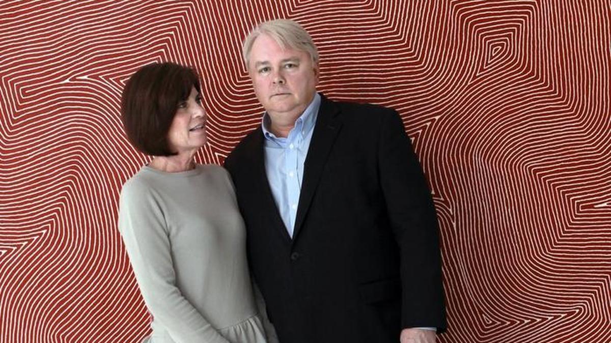 Debra and Dennis Scholl stand in front of an acrylic on canvas work by Warlimpirrnga Tjapaltjarri in their Miami Beach home in this 2012 photo. Longtime art collectors and supporters of the arts in Miami, the couple has donated nearly 200 works of aboriginal art to three U.S. museums.
