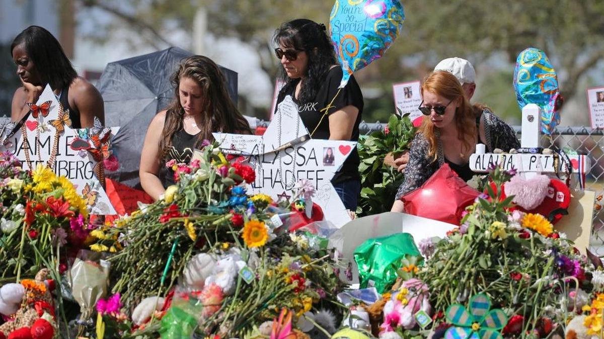 Mourners bring flowers as they pay tribute at a memorial for the victims of the shooting at Marjory Stoneman Douglas High School on Sunday, Feb. 25, 2018. The memorial was taken down Wednesday and will be preserved at Florida Atlantic University.