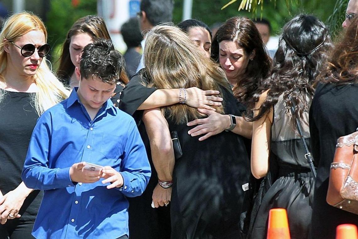 Mourners hug and console each other outside the funeral of shooting victim Martin Duque from Marjory Stoneman Douglas High School on Sunday, Feb. 25, 2018.