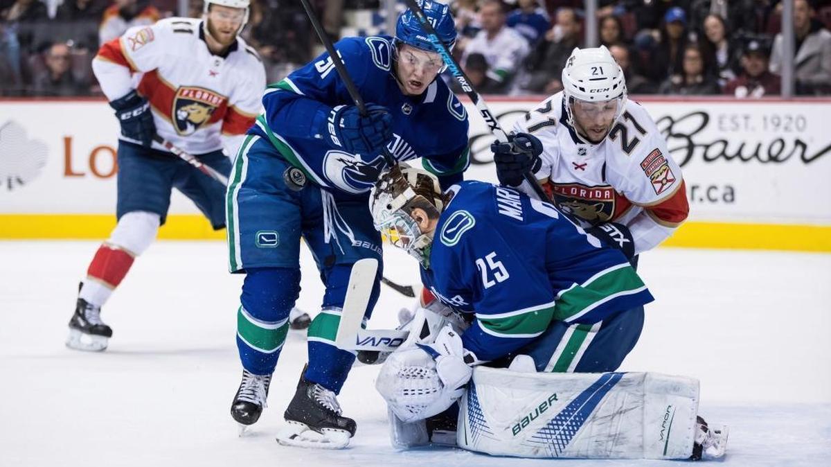 Vancouver Canucks goalie Jacob Markstrom (25), of Sweden, makes the save as Troy Stecher (51) defends against Florida Panthers' Vincent Trocheck (21) during the first period of an NHL hockey game Wednesday, Feb. 14, 2018, in Vancouver, British Columbia. The Florida Panthers, with several players and their families living in Parkland, had their minds across the continent from their game in Vancouver.