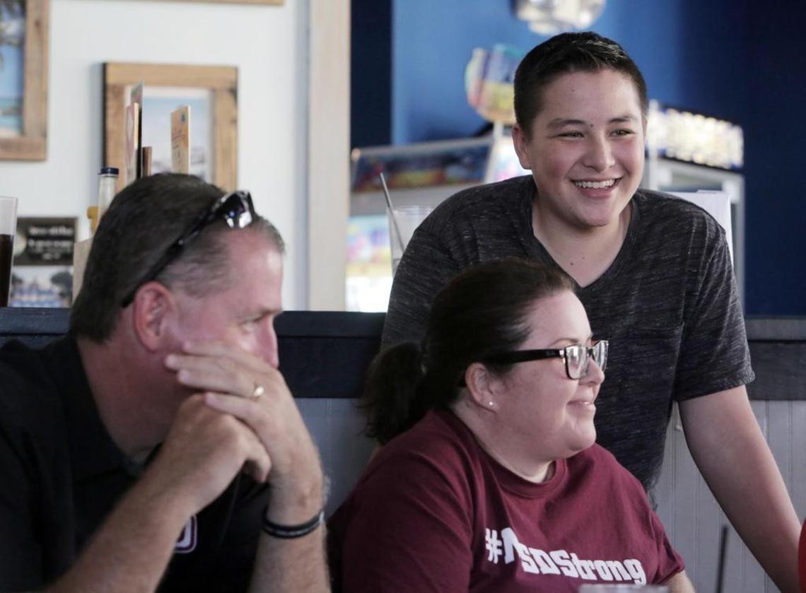 Kyle Laman (standing, right) with his mom Marie Laman (right) and Sgt. Jeff Heinrich (left) at Hurricane Wings & Grill during a fundraiser for Kyle’s recovery fund in Coral Springs on April 28.