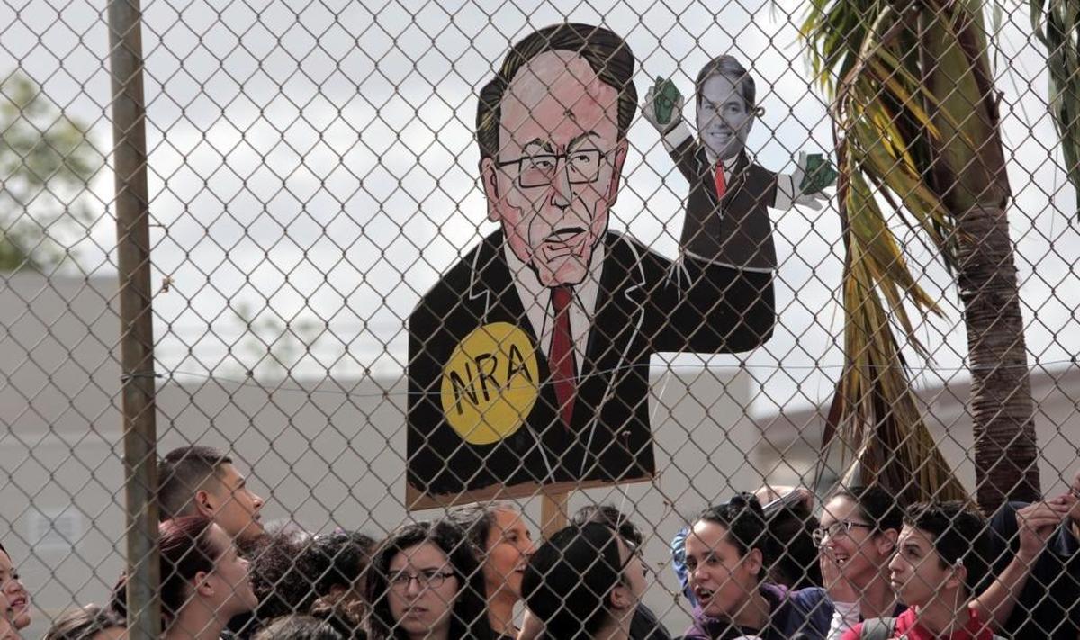 A sign bearing the likeness of NRA leader Wayne LaPierre holding a Marco Rubio puppet is displayed at a protest by students at Hialeah Senior High School Wednesday.