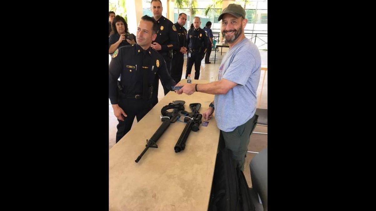 Steve Hemmert turned in his two AR-style rifles to Miami police Saturday, March 17, 2018, as part of the department’s gun buyback event.
