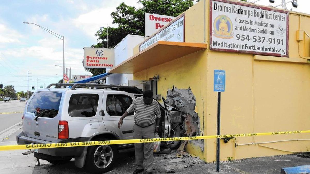 
Time to reflect: Rosias Octeus, 65, removes belongings from his wrecked Nissan SUV after he crashed the vehicle into the Drolma Kadampa Buddhist Center, 140 W. Prospect Road in Oakland Park. No one was injured in the crash, which happened about 2:35 p.m. Aug. 10, 2015.
