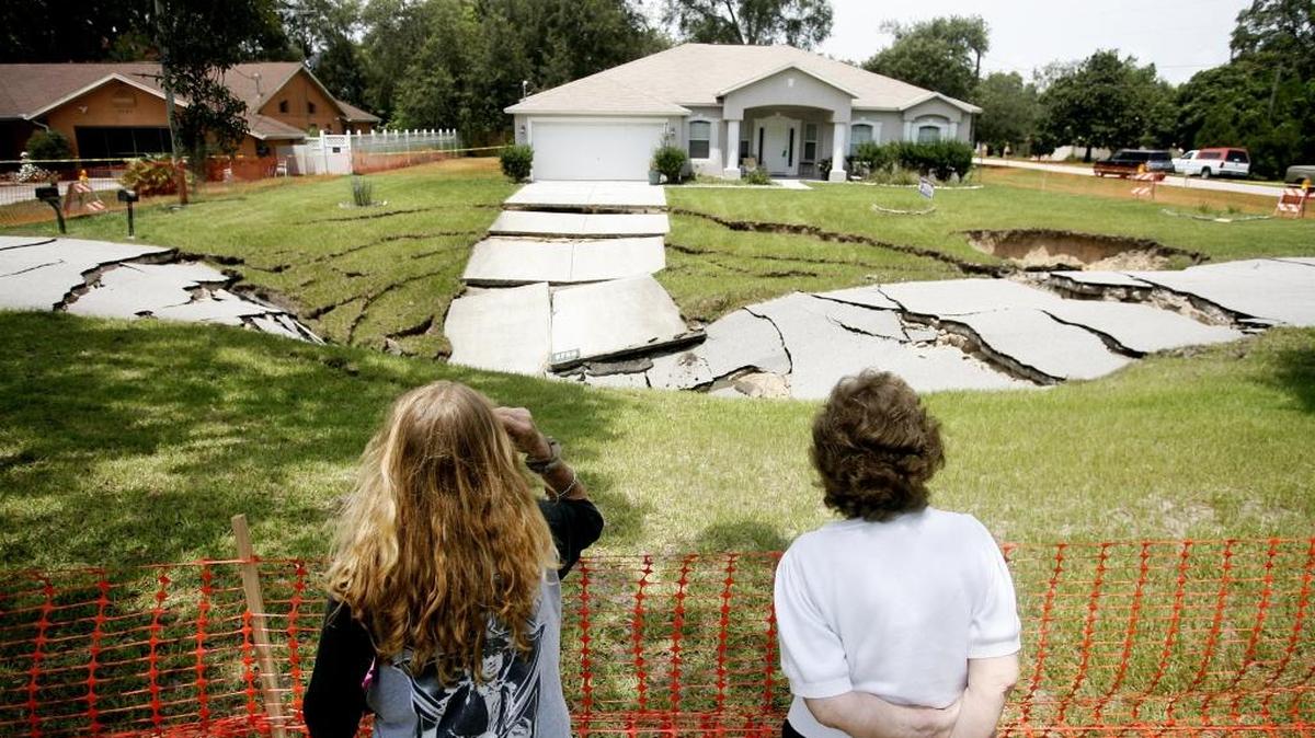 Kim Russell, left, and her mother Betty Box examine the massive sinkhole that opened in Spring Hill, on Sunday, July 20, 2014.