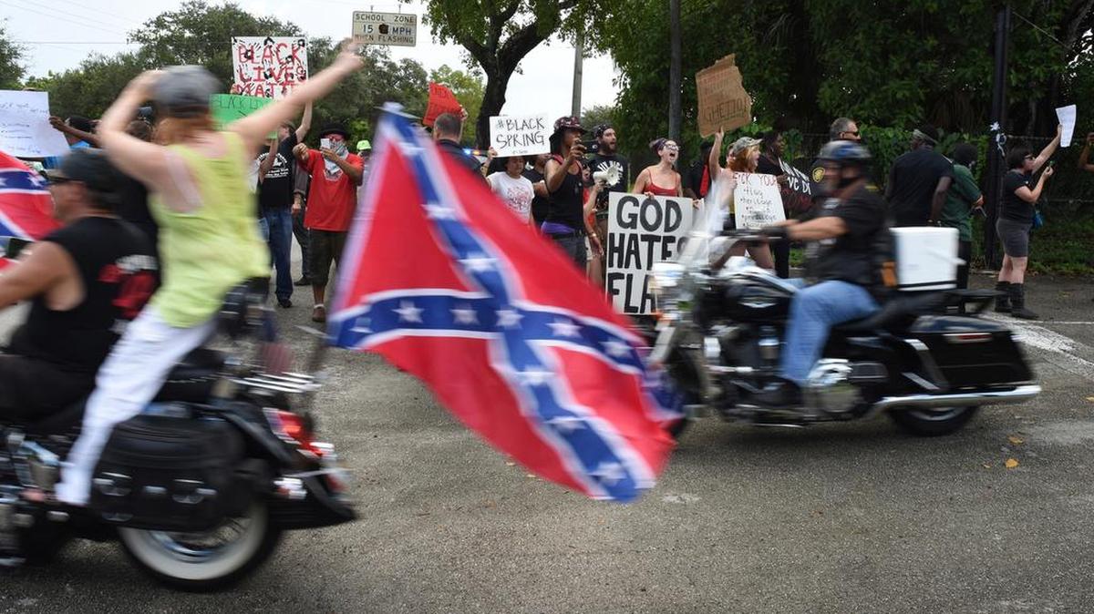 
Differing opinions: Supporters of the Confederate flag ride past protesters to rallies at Heritage Park and Markham Park on Sunday. 
