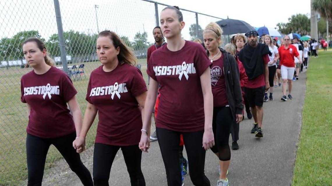 From left, Kristen Barber, Debbie Sajek and Lauren Sajek participate in a walk and remembrance in a show of solidarity with the victims of the Parkland school shooting on Saturday, March 10, 2018. The walk started at North Community Park in Coral Springs and ended at Marjory Stoneman Douglas High School in Parkland.
