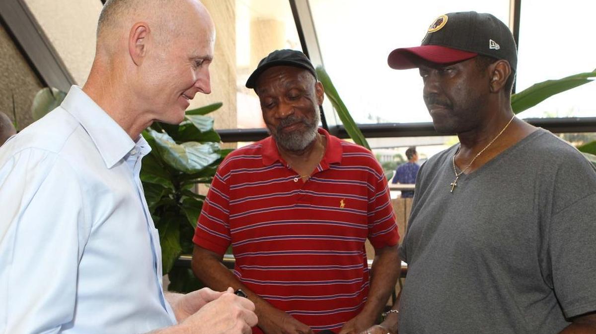 Florida Gove. Rick Scott speaks to Ronald Mackey (center) and Charod Oliphant at Terminal 2 on Saturday, Jan. 7, 2016. Mackey and Oliphant saw Gov. Rick Scott in the airport and approached him. They need to catch a cruise but don’t have their luggage