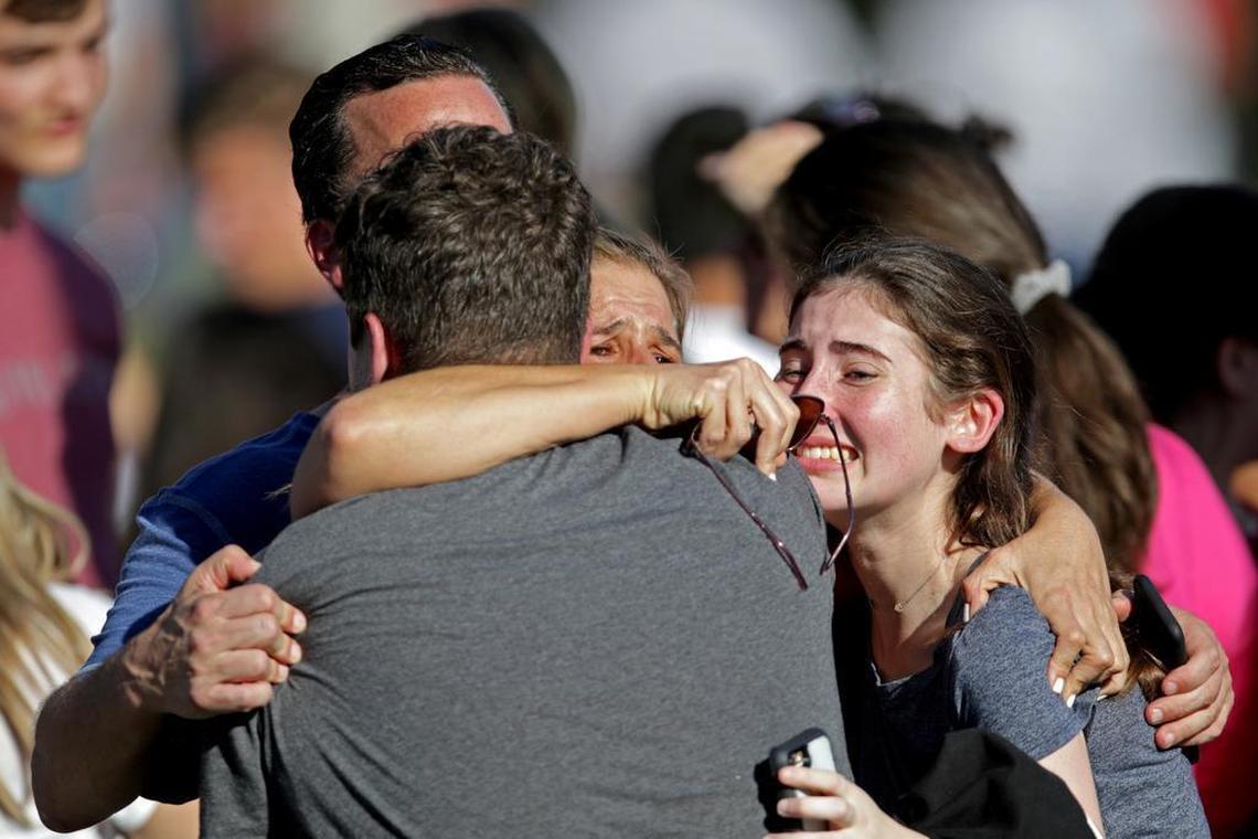 A family reunites outside of Marjory Stoneman Douglas High School in Parkland after Nikolas Cruz killed 17 people on Feb. 14.