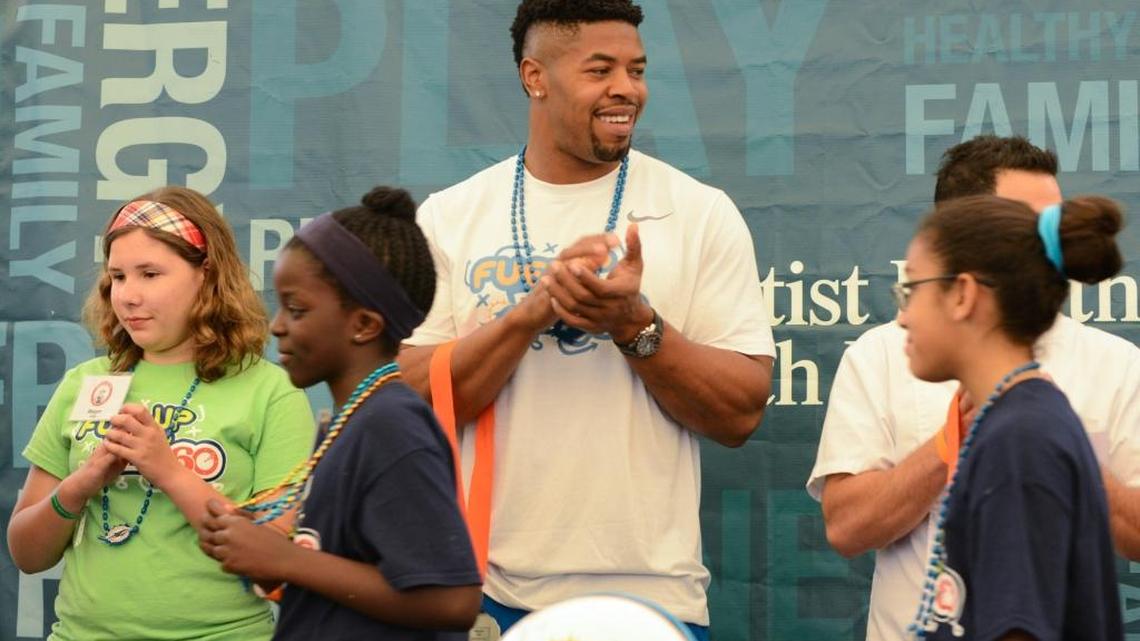 Miami Dolphins defensive end Cameron Wake, center, congratulates the Dairy Council of Florida's third annual Gridiron Cooking Challenge participants at the Miami Dolphins Training Facility in Davie on Saturday, April 16. Students competed for a $2,500 prize pack by preparing original breakfast recipes that included some form of dairy.