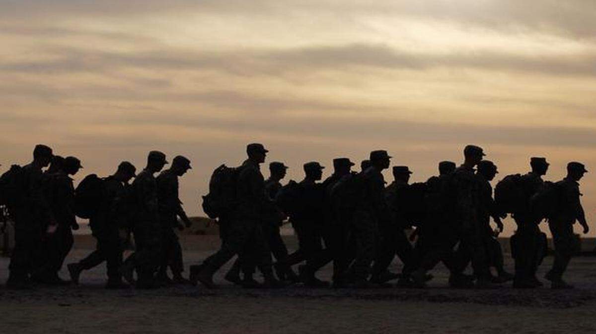 
FILE--U.S. Army soldiers  walk to where they will board buses to fly home to Fort Hood, Texas after being one of the last American combat units to exit from Iraq on Dec. 15, 2011 at Camp Virginia, near Kuwait City, Kuwait. 
