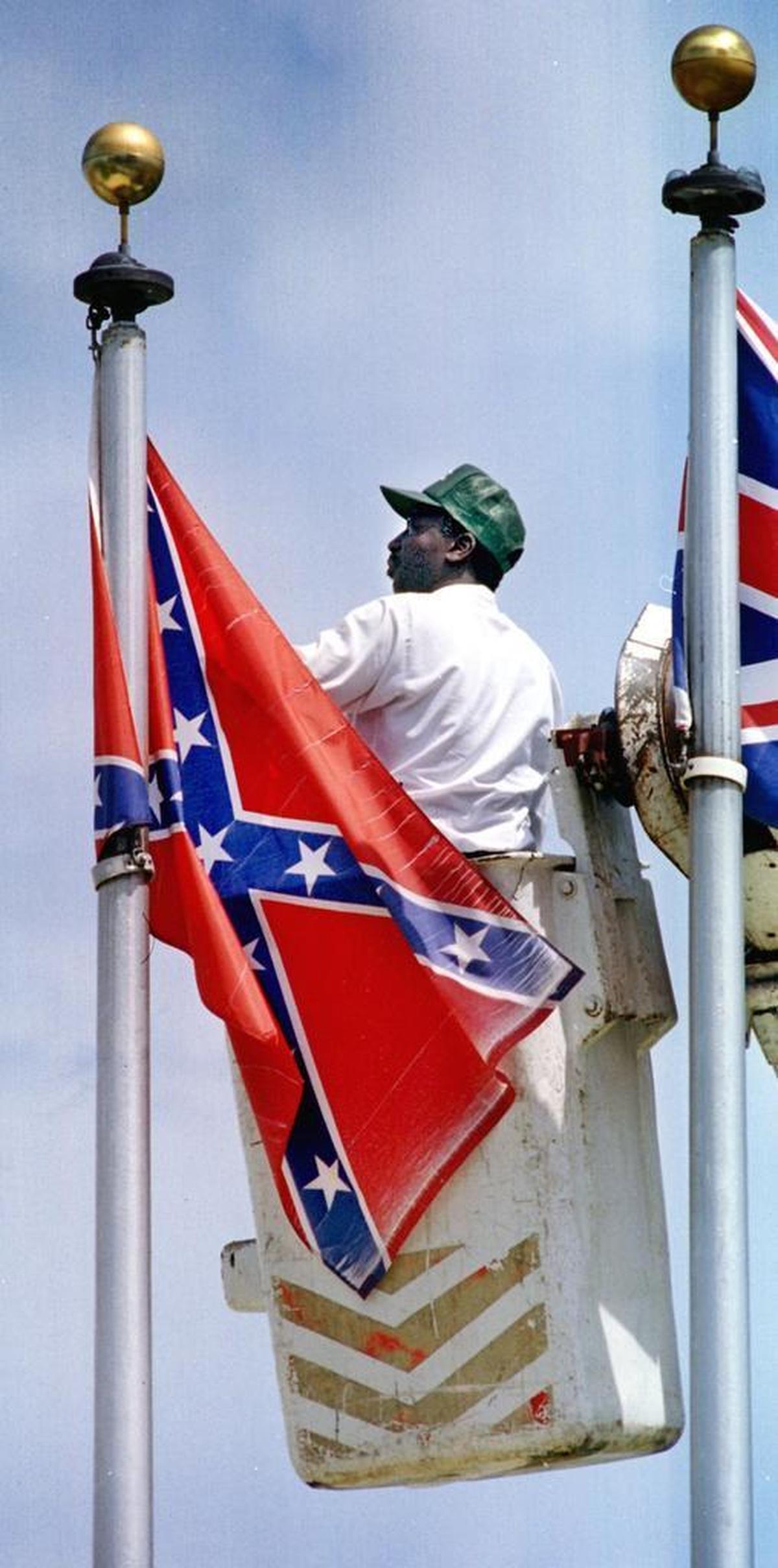 David Mizell, a heavy equipment operator for Hollywood’s public works department, removes the Confederate flag from Young Circle.