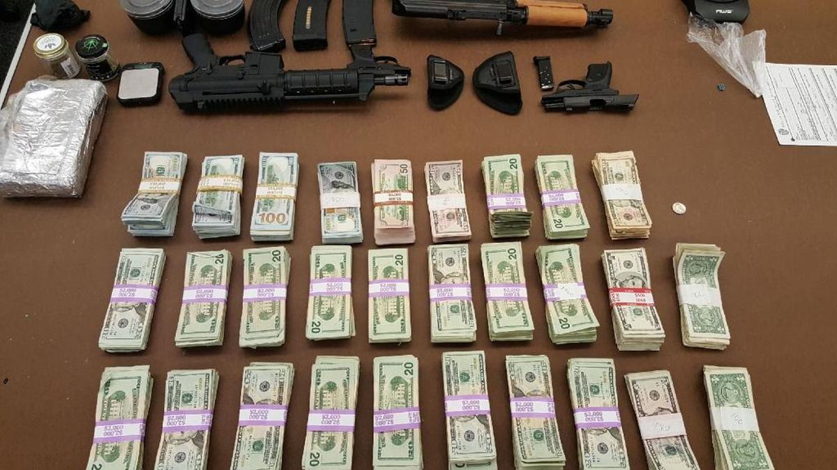 Cash, guns and, wrapped in foil on the left, drugs allegedly seized in Monday’s arrest at 7100 Park Street