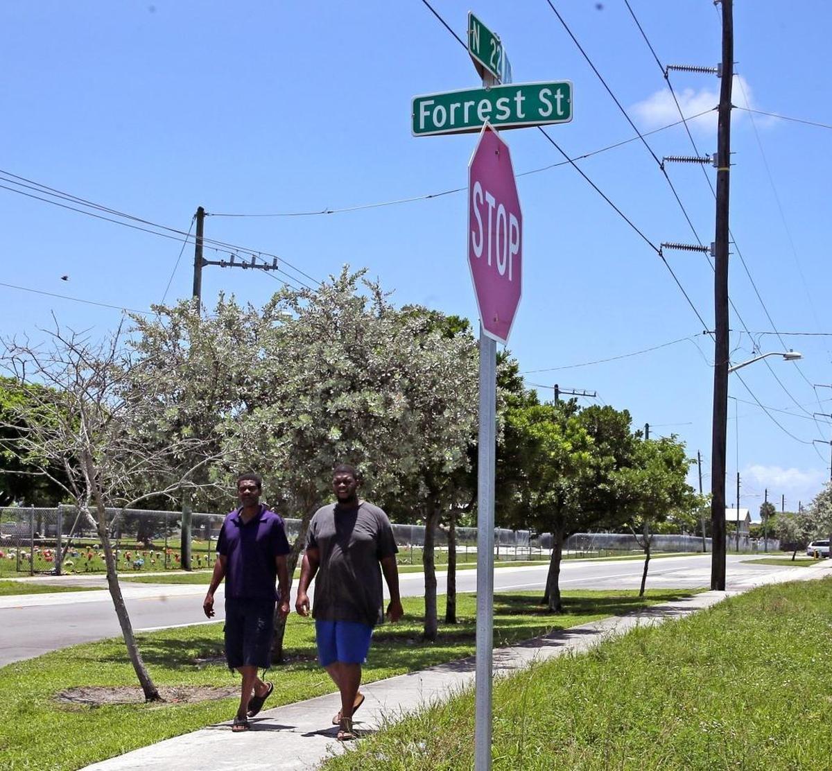 Thomas Lewis and Bernard Hawkins walk by a Forrest Street sign at Northwest 22nd Avenue in Hollywood. The street was named after Confederate Gen. Nathan Bedford Forrest, considered a founder of the Ku Klux Klan.