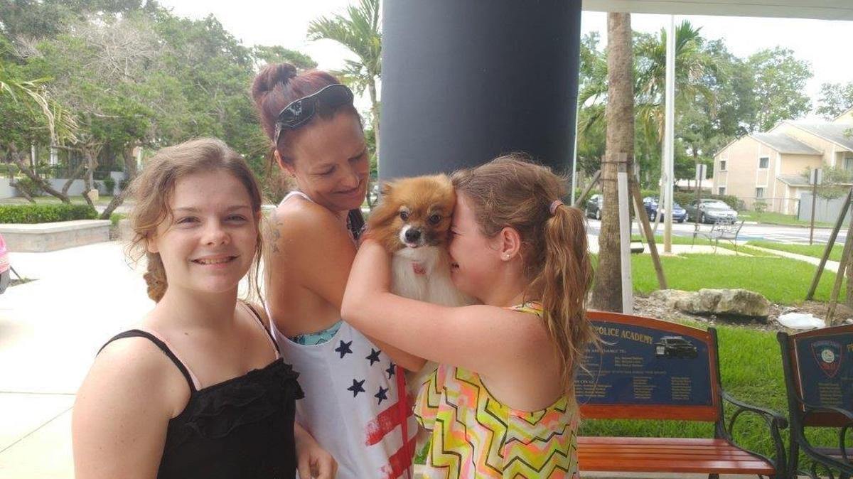 Joy Meeks, 30, poses for a photo with her 12-year-old twin daughters, Alexia and Kylie, and their dog, Sassy. The 6-year-old Pomeranian disappeared in January from her Bradenton home. Police in Pembroke Pines said Thursday they found her by the side of the road earlier this month. She was 200 miles away from her Bradenton home.