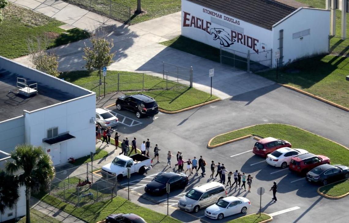 Students are evacuated by police out of Marjory Stoneman Douglas High School in Parkland after a shooter opened fire on the campus.