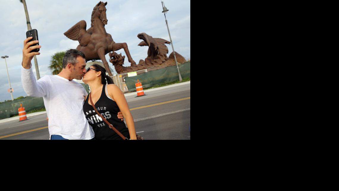 
Jorge Méndez and his wife, Elena Alvarez, pose for a photo in front of the $30 million bronze Pegasus statue at the Village of Gulfstream Park that is set to be completed soon.


