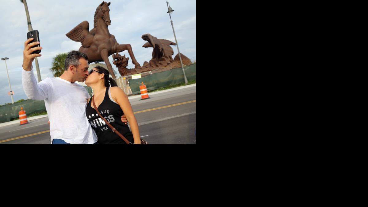 
Jorge Méndez and his wife, Elena Alvarez, pose for a photo in front of the $30 million bronze Pegasus statue at the Village of Gulfstream Park that is set to be completed soon.


