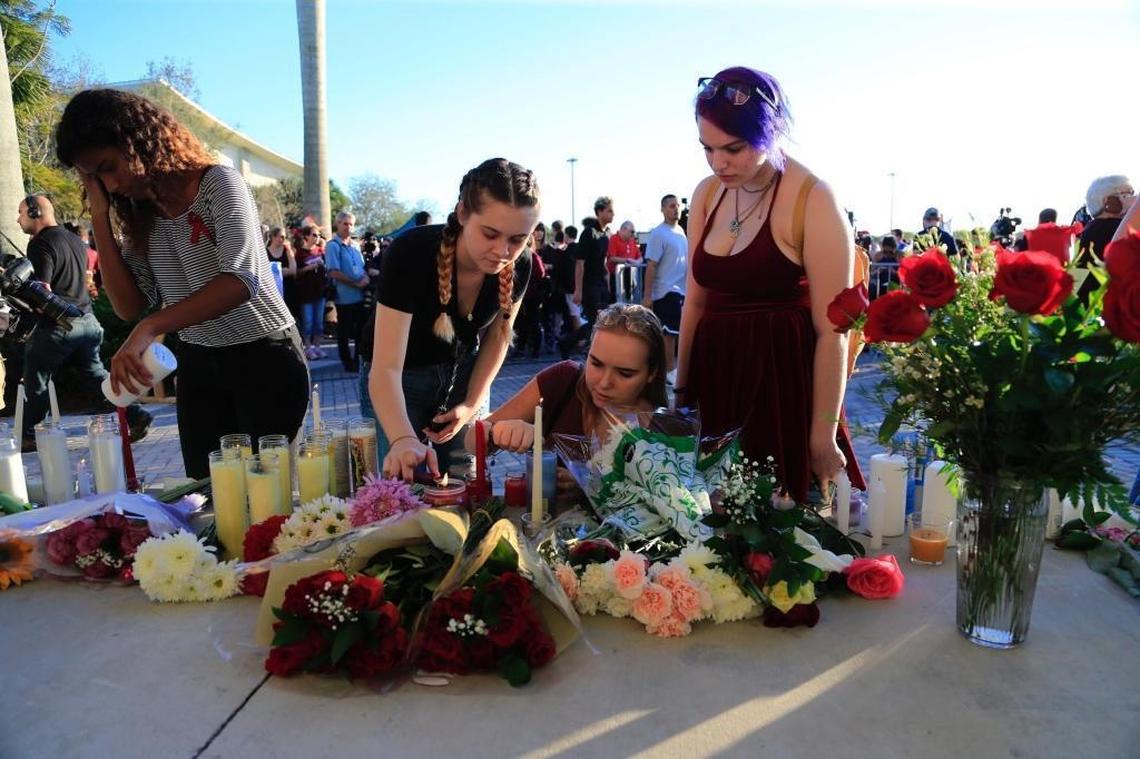 Teenagers light candles during a vigil at Pine Trails Park for victims of the shooting at Marjory Stoneman Douglas High School.