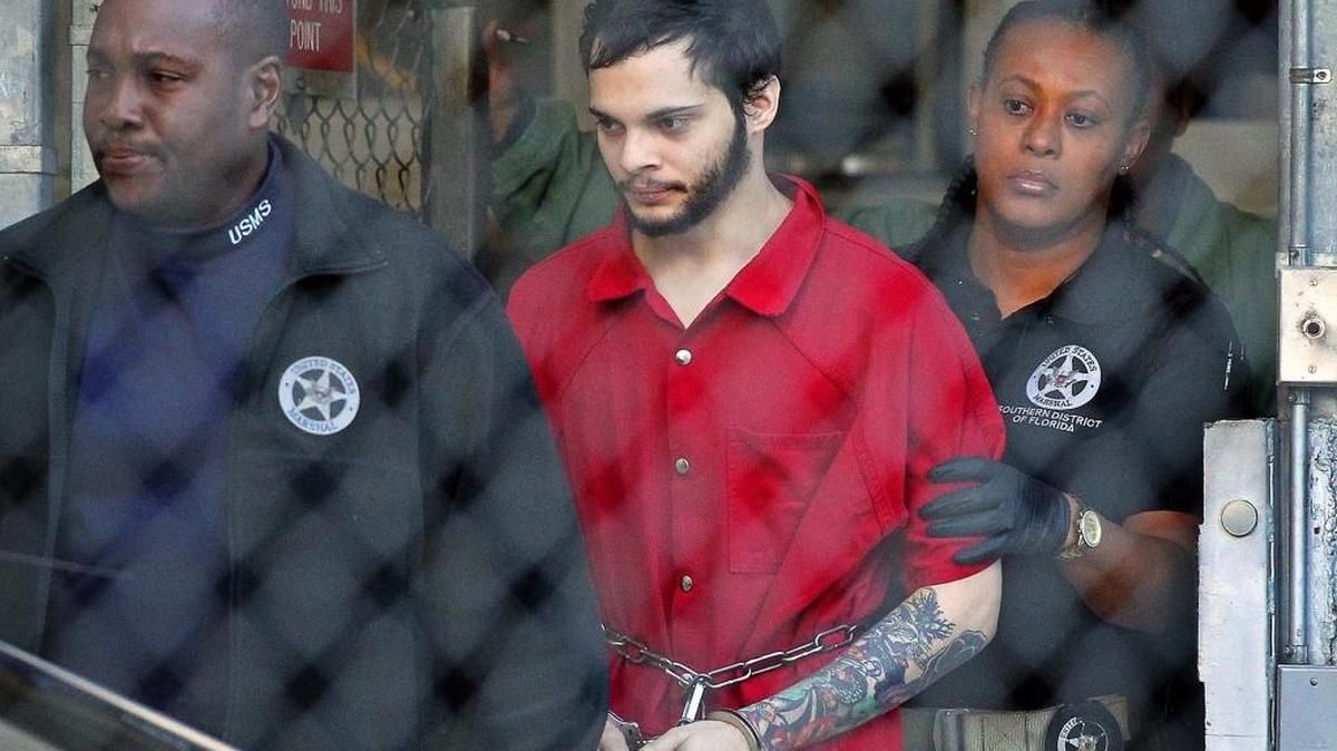 Esteban Santiago, the Fort Lauderdale airport shooting suspect, exits the jail accompanied by two federal officers.