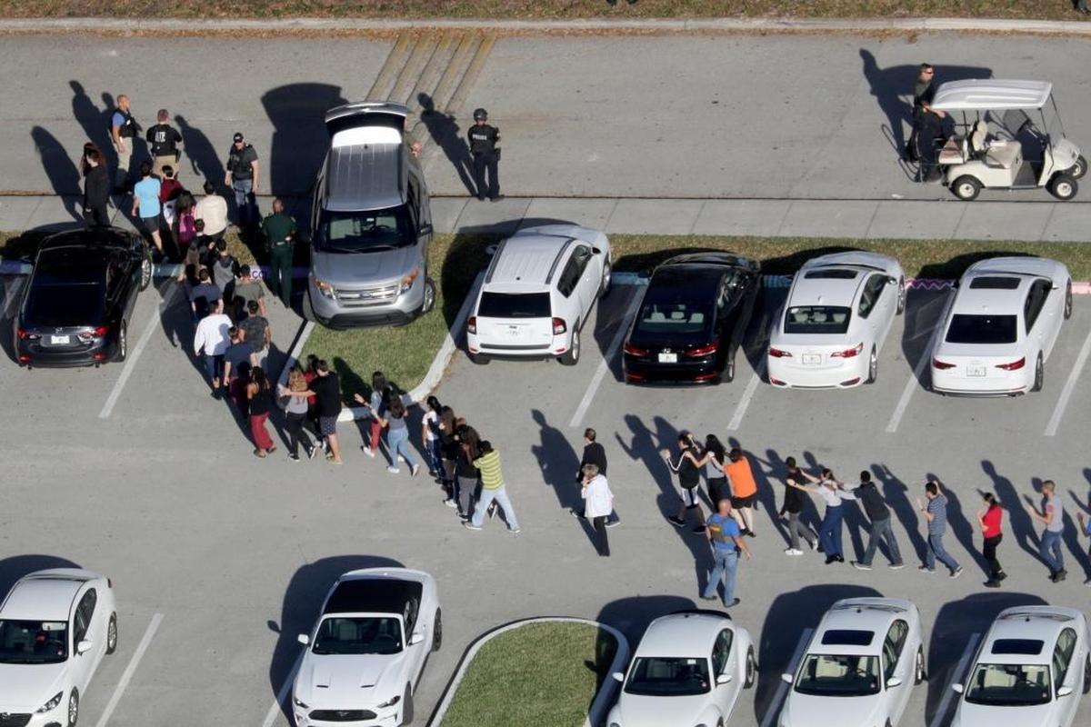 Students are evacuated by police from Marjory Stoneman Douglas High School in Parkland, Fla., after a shooter opened fire on the campus.