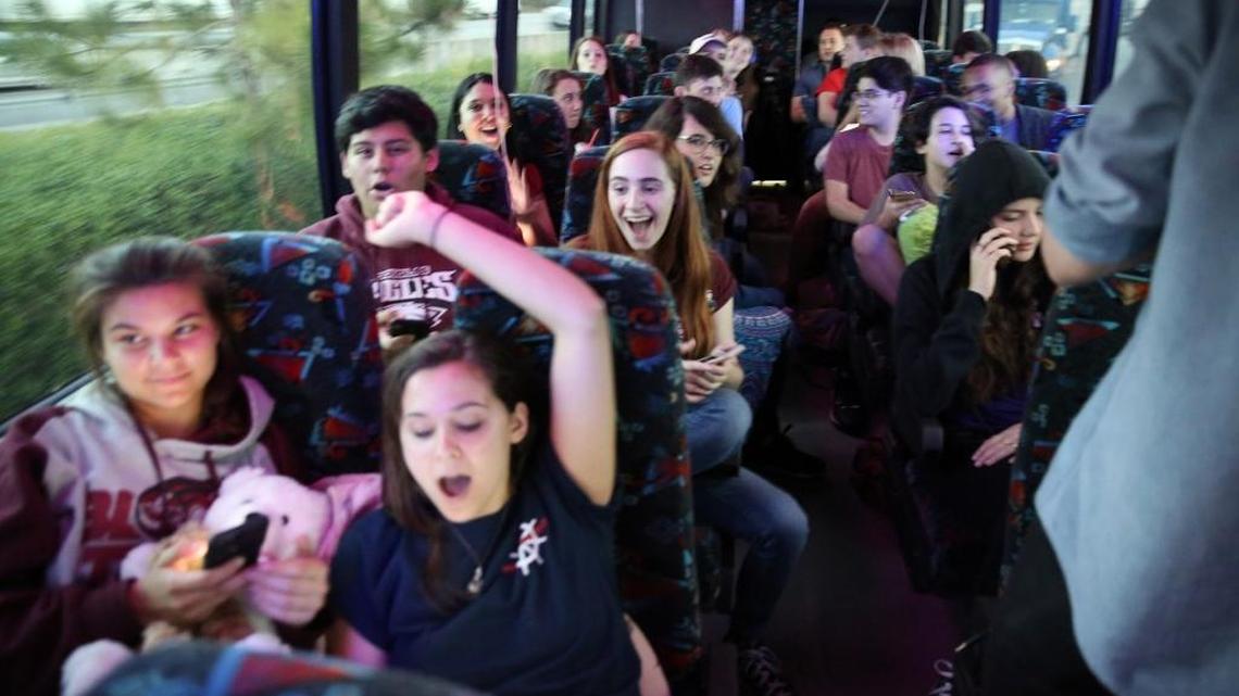 Stoneman Douglas students, Lindsey and Julia Salomone (front row) and Jose Iglesias and Isabelle Robinson react to news that Oprah donated $500,000 to their “March For Our Lives” GoFundMe aboard one of three buses headed to Tallahassee Tuesday, Feb. 20, 2018, to demand stronger gun control.