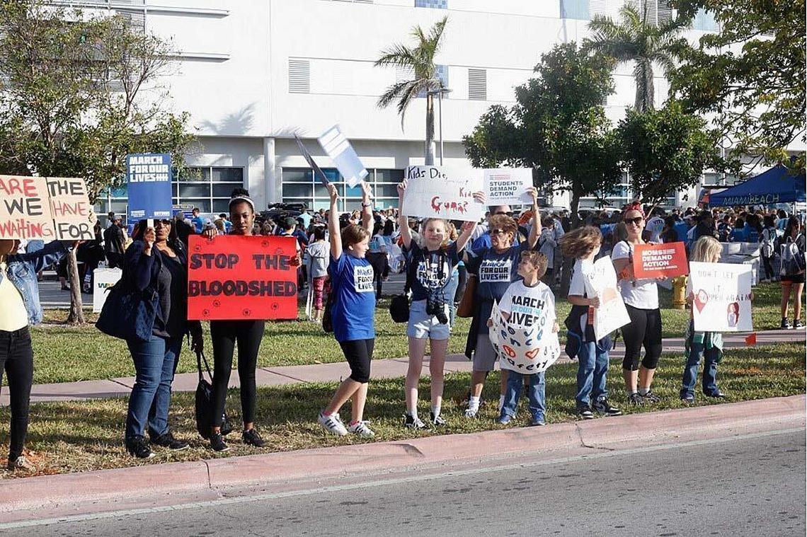 Participants line up and hold signs during the Walk For Our Lives rally in Miami Beach on Saturday.