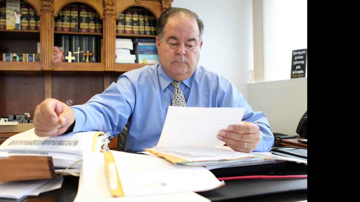 
Eduardo Soto, a Coral Gables attorney, looks over documents for his client, Miguel Romero Diaz. He has obtained permanent residency more than 50 years after entering the U.S. illegally across the Mexican border.


