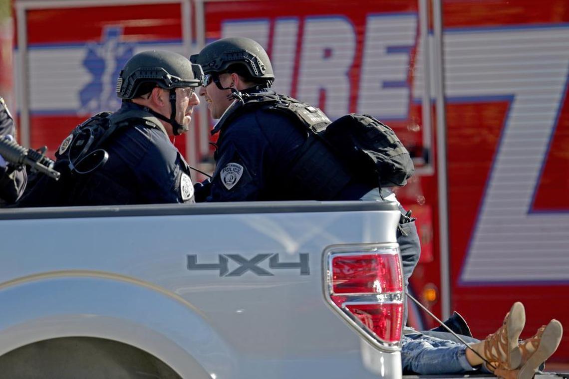 Police officers ride in the back of a pickup truck with a victim outside of Stoneman Douglas High School in Parkland after reports of an active shooter Wednesday, Feb. 14, 2018.