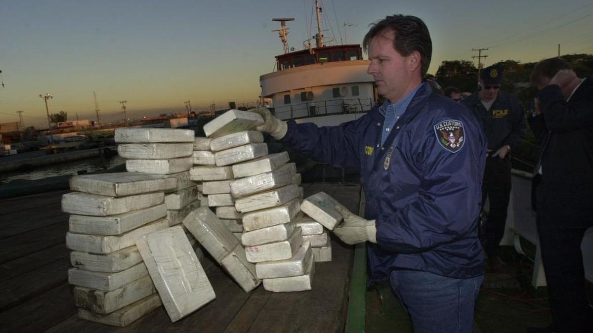 Zach Mann, of U.S. Customs, counts bricks of cocaine found in a boat at a marina on the Miami River in 2002.