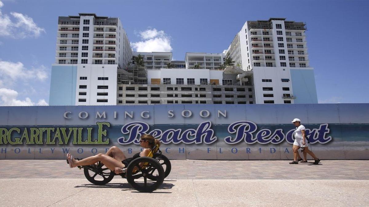
Margaritaville Hollywood Beach Resort is under construction as tourist and locals alike pass by the development's decorative wall on Hollywood Beach.
