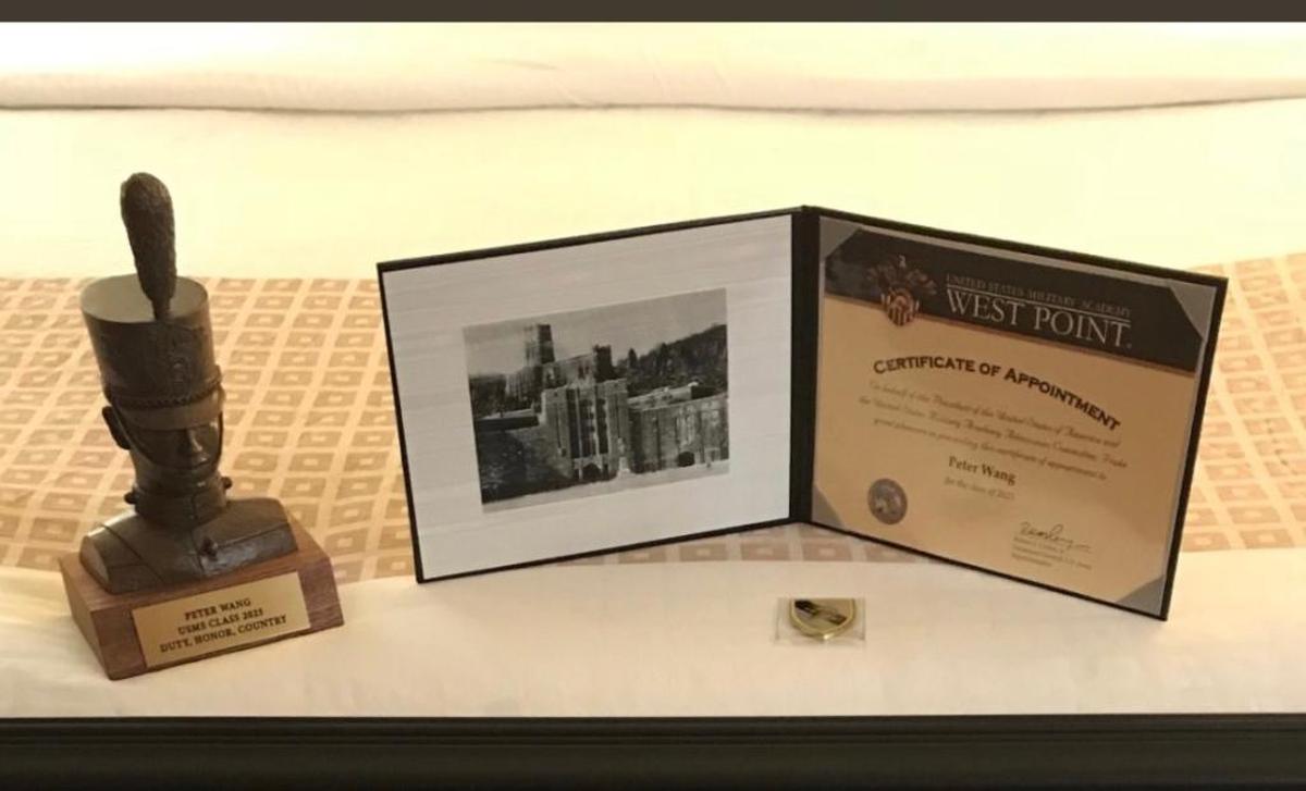 Peter Wang’s posthumous certificate of appointment to West Point’s Class of 2025, a commemorative coin and a bronze bust of a West Point Cadet in a photograph posted on the U.S. Military Academy at West Point Twitter page.