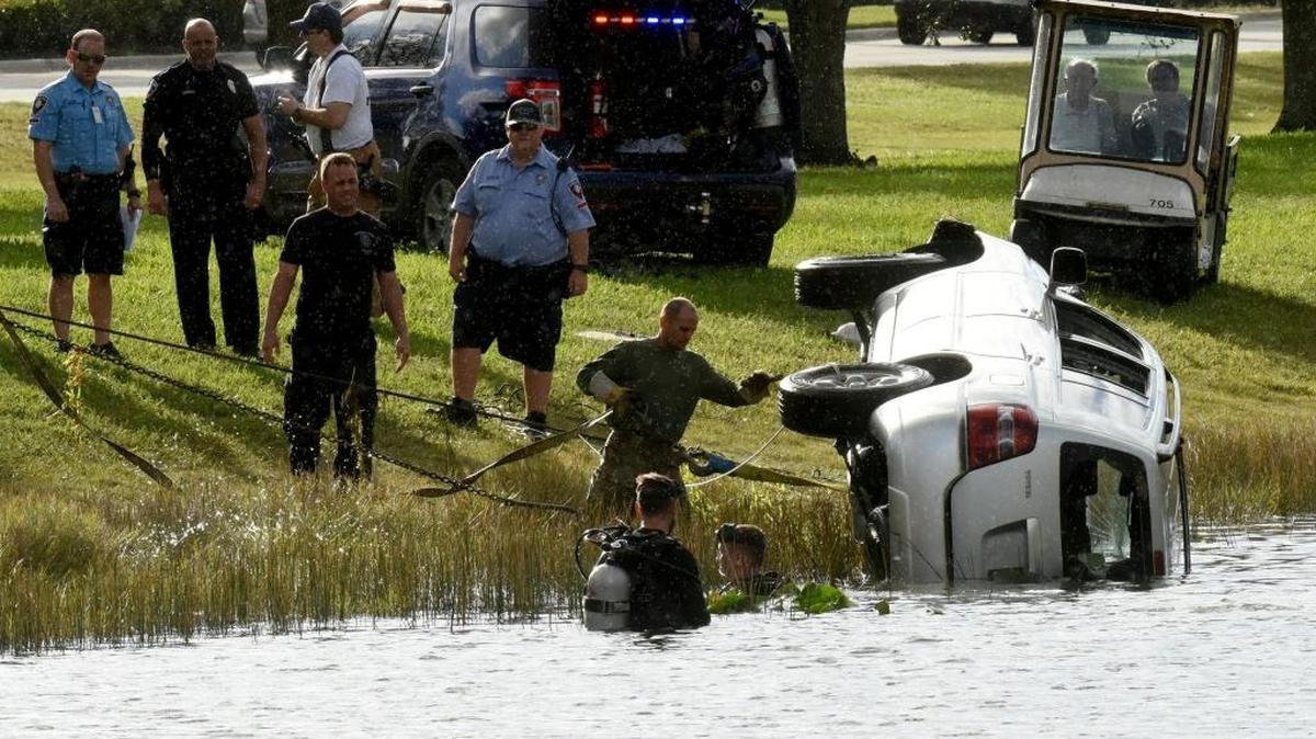 Pembroke Pines police and tow truck operators work to get a 2004 Toyota Highlander out of a canal after Sandy Rose and Joan Rose were pulled from the submerged vehicle. The SUV crashed into the canal near the Southwest Regional Library.