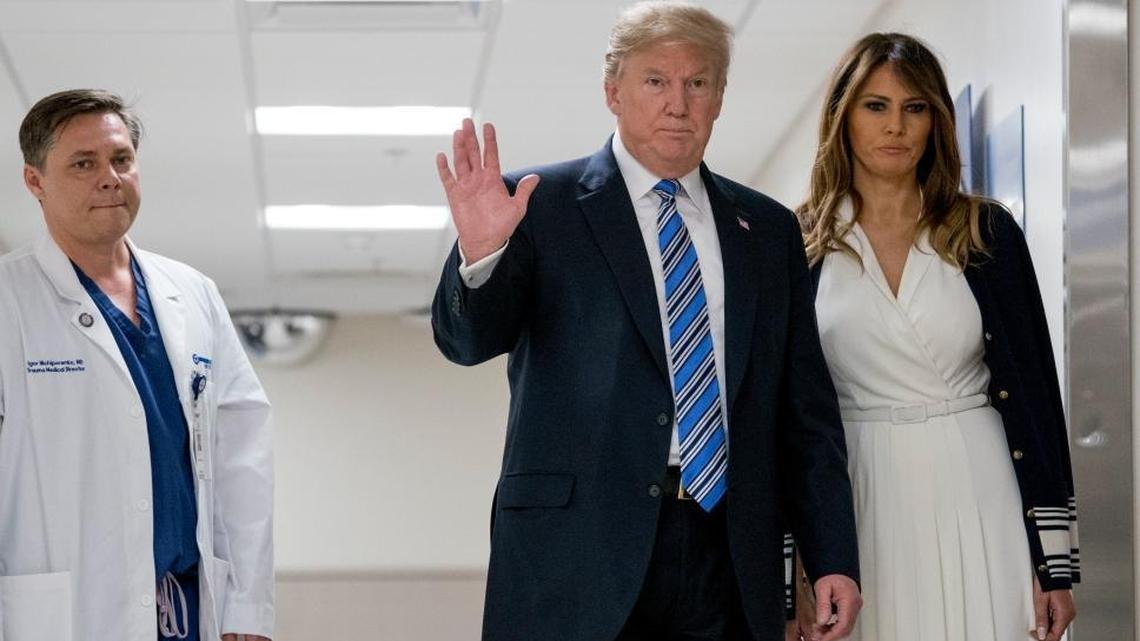 President Donald Trump, accompanied by first lady Melania Trump, and Dr. Igor Nichiporenko, waves to reporters while visiting with medical staff at Broward Health North in Pompano Beach, Fla., Friday, Feb. 16, 2018, following Wednesday’s shooting at Marjory Stoneman Douglas High School, in Parkland, Fla.