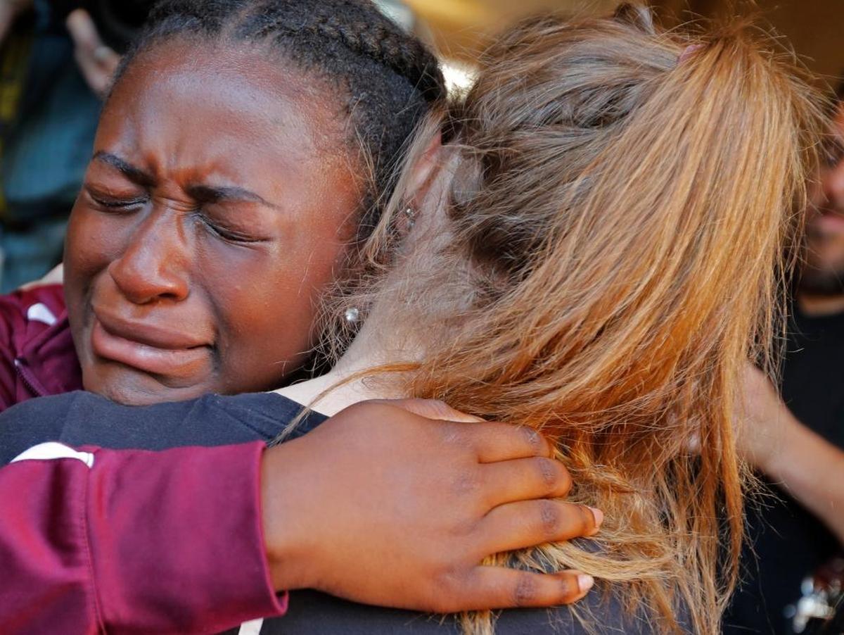 Marla Eveillard, 14, cries as she hugs friends before the start of a vigil at the Parkland Church, for the victims of Wednesday’s shooting at Marjory Stoneman Douglas High School in Parkland.